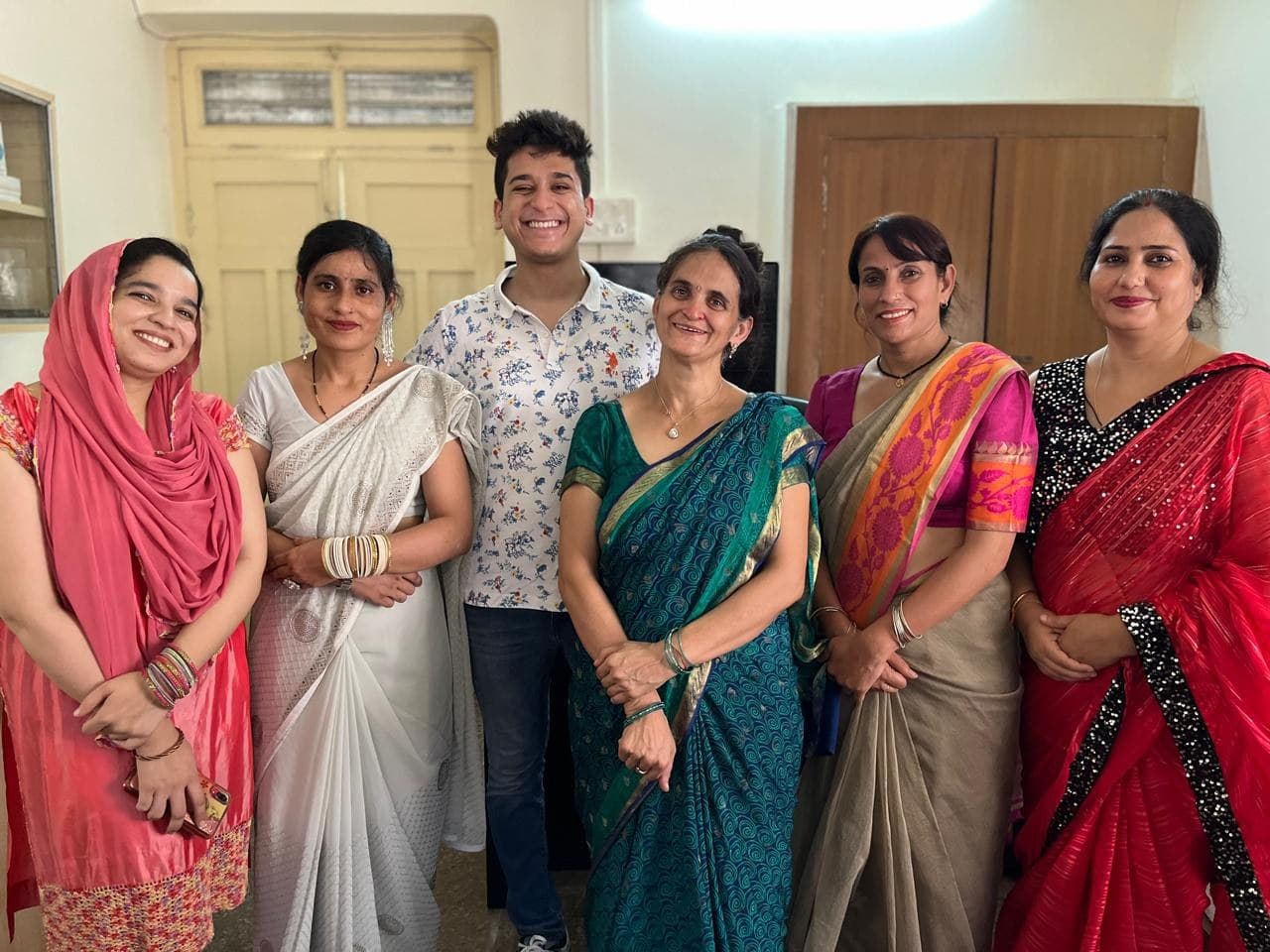 Kushagra standing among five faculty members in a classroom doorway at Adarsh Women’s Polytechnic.