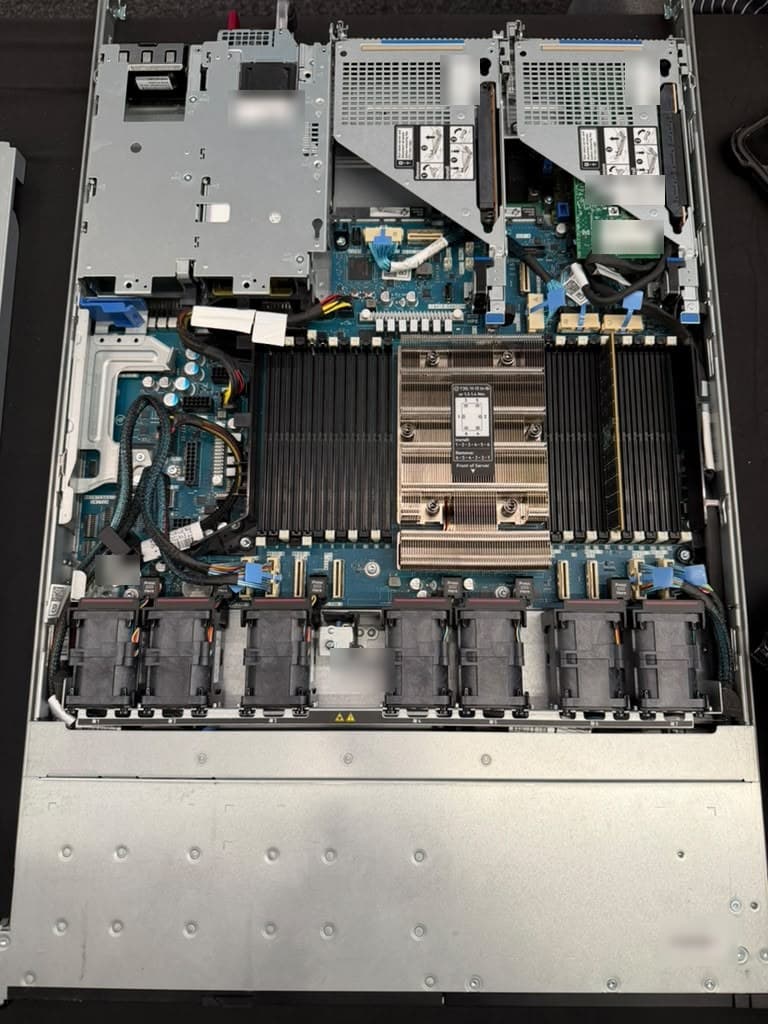 A single-processor server seen from above with its lid off: a large heatsink, rows of memory slots, a row of fans and two expansion risers.