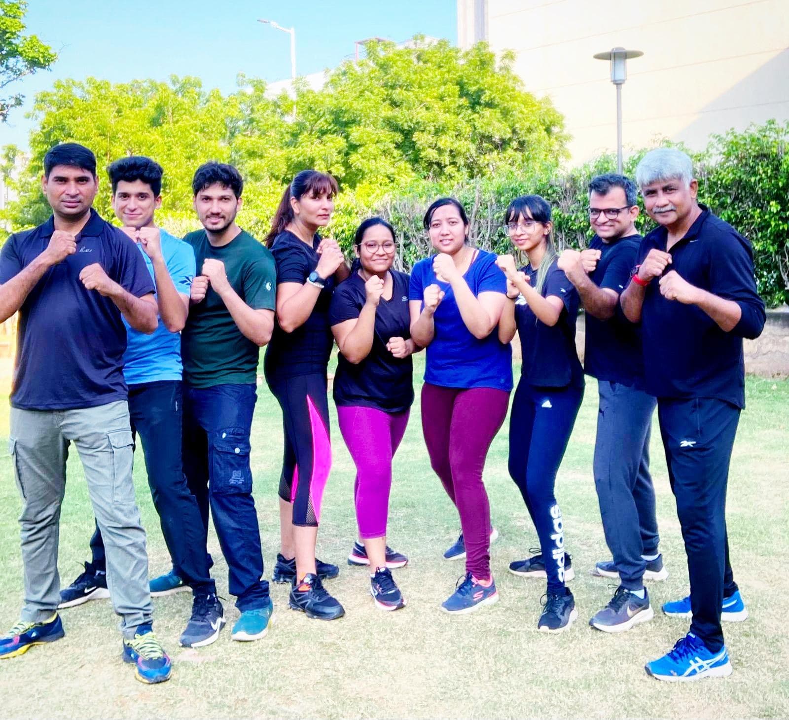 An outdoor self-defence training group of ten standing in guard stance mid-session.